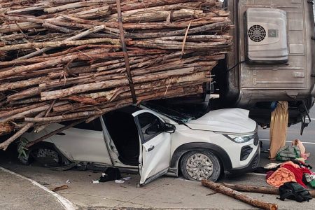 Carreta tomba e carga de madeira atinge carro em Pituaçu