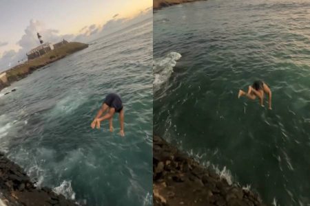 Jovens se arriscam em saltos no mar perto de pedras no Farol da Barra