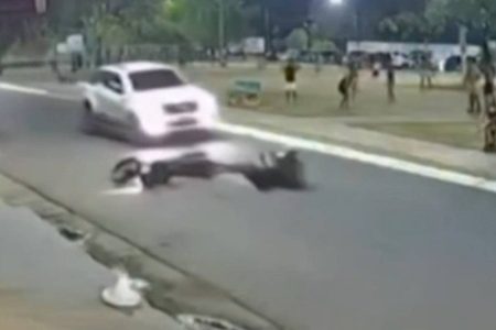 Motociclista cai após ser atingido por bola de futebol e quase é atropelado